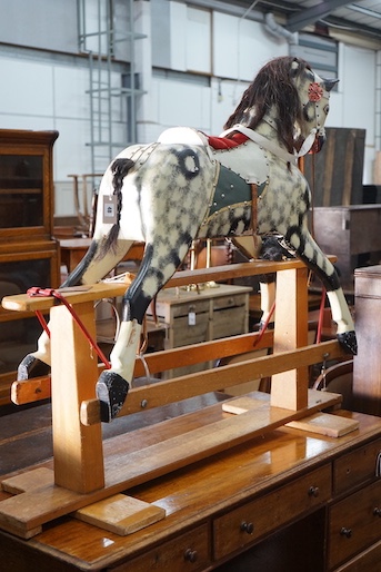 A vintage Ayres type dapple grey carved wood rocking horse on beech safety frame, length 130cm, height 115cm